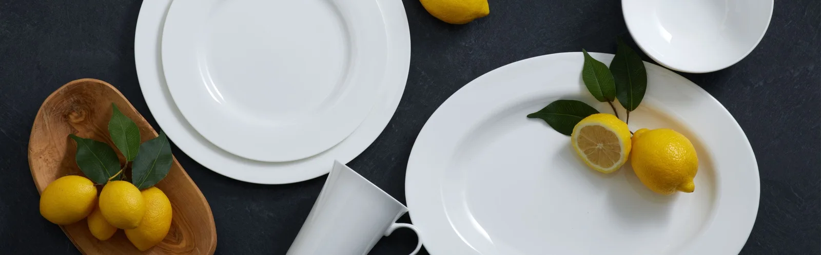 Mikasa manufacturer photograph of clean white Delray pieces with lemons and wooden serving accessories